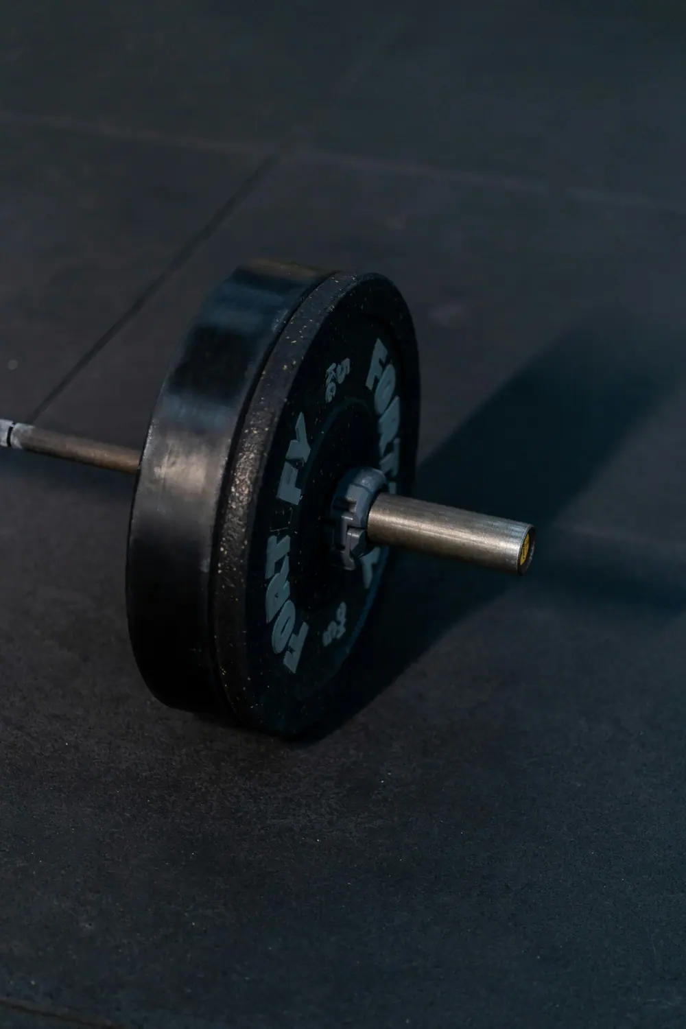 A loaded barbell resting on the gym floor